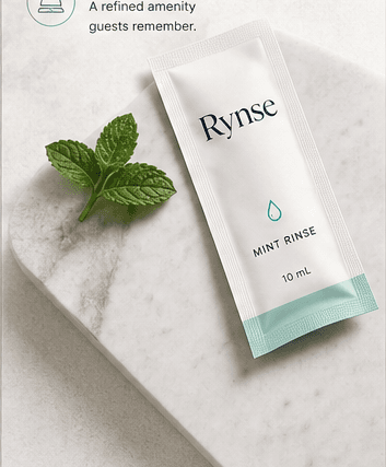 Rynse mint rinse packet beside fresh mint on a marble surface